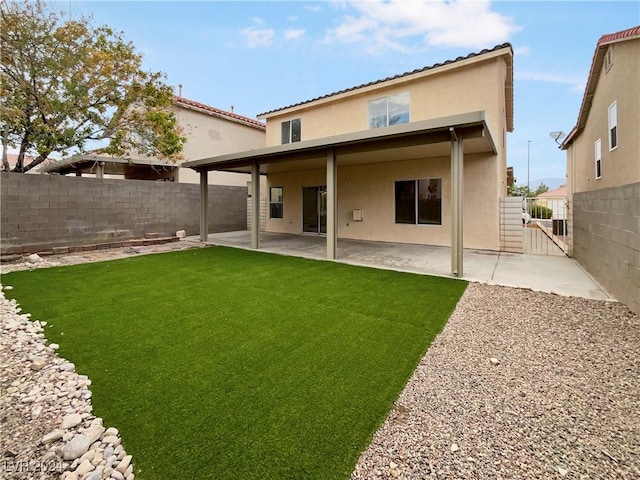 back of house with a patio, a yard, a fenced backyard, and stucco siding