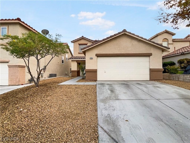 view of front of house with a tile roof, a garage, driveway, and stucco siding