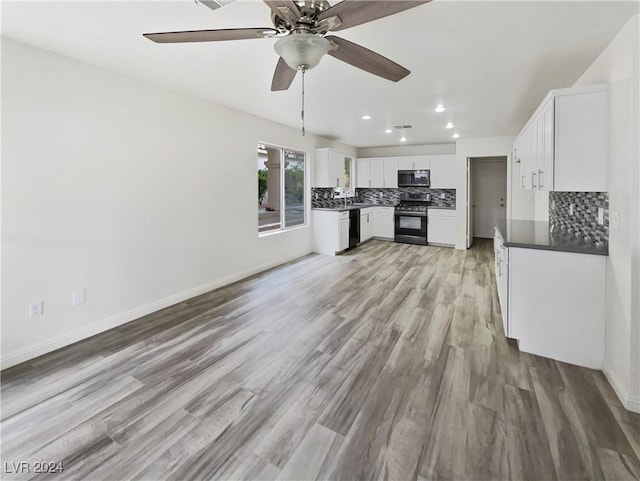 kitchen featuring decorative backsplash, light wood-style floors, black appliances, and white cabinets