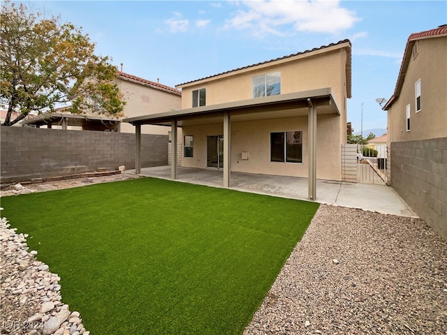 rear view of house with a lawn and a patio area