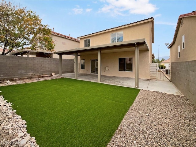 rear view of house featuring a fenced backyard, stucco siding, a yard, and a patio