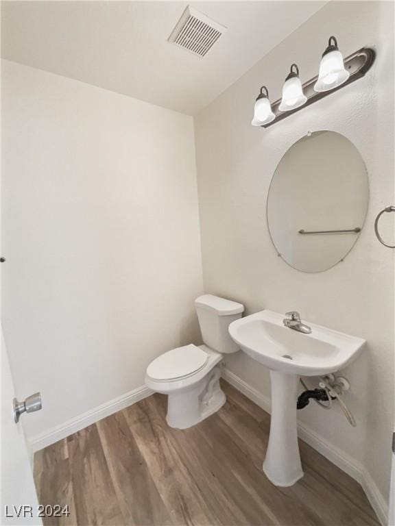 bathroom with visible vents, baseboards, toilet, and wood finished floors