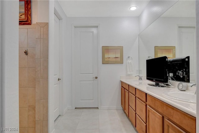 bathroom with tile patterned floors, double vanity, baseboards, and a sink