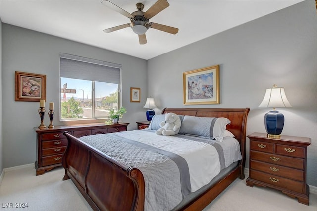 bedroom featuring baseboards, light colored carpet, and ceiling fan