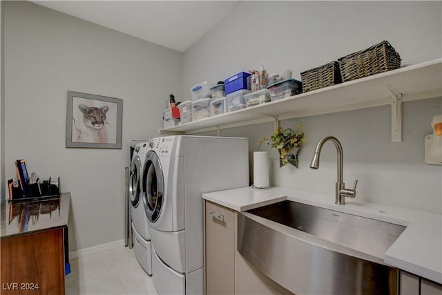 laundry area featuring baseboards, light tile patterned floors, laundry area, washer and dryer, and a sink