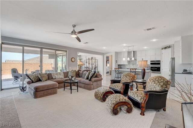 carpeted living room with ceiling fan