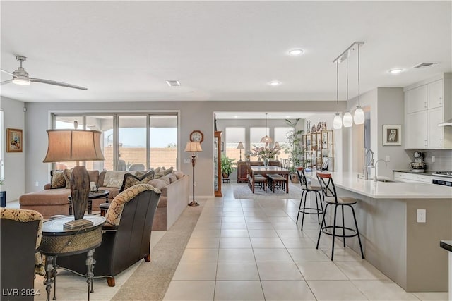 living room featuring light tile patterned flooring, recessed lighting, visible vents, and ceiling fan