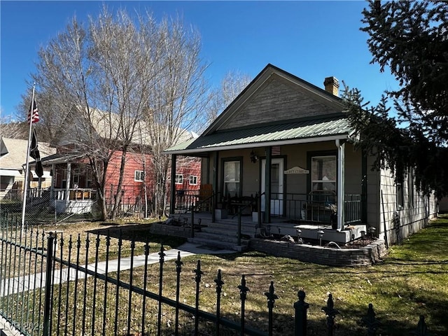 bungalow-style house featuring covered porch and a front yard