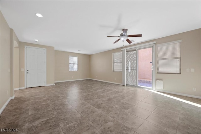 tiled spare room with ceiling fan