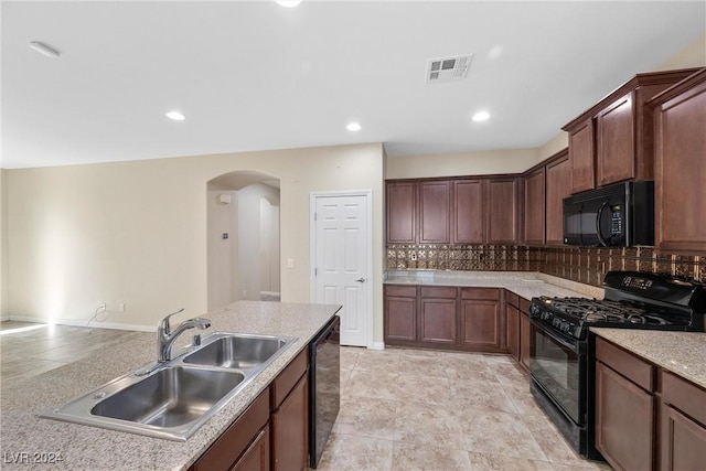 kitchen with decorative backsplash, sink, light stone counters, and black appliances