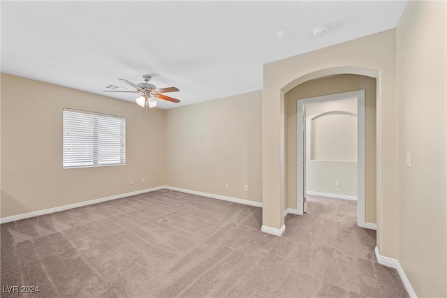 carpeted spare room featuring ceiling fan