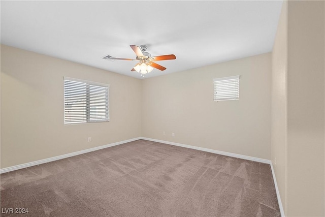 carpeted spare room with a wealth of natural light and ceiling fan