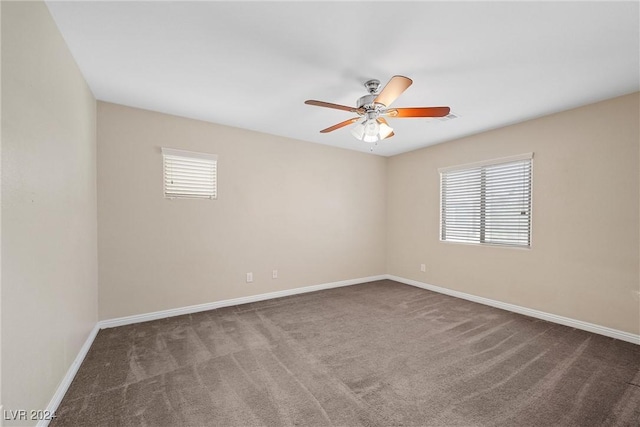 spare room featuring ceiling fan and dark colored carpet