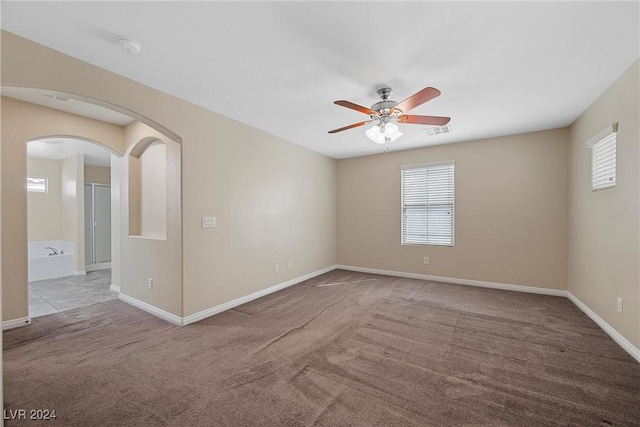 carpeted empty room featuring ceiling fan