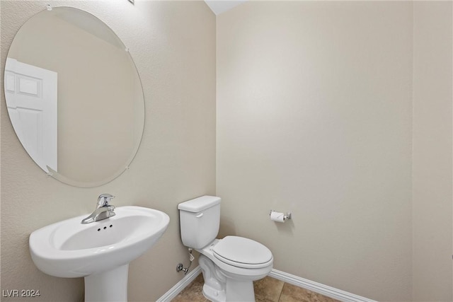 bathroom featuring tile patterned flooring, toilet, and sink