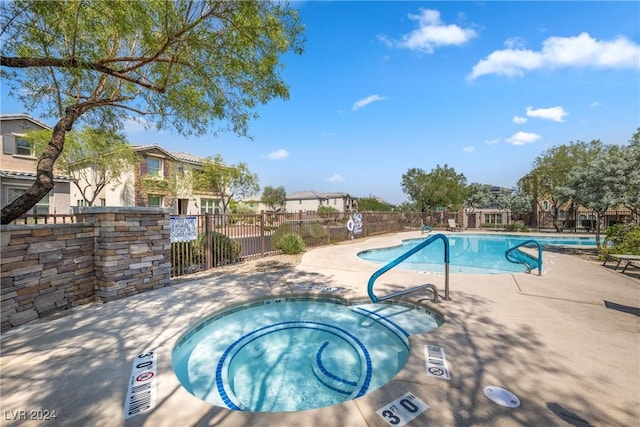 view of pool with a hot tub