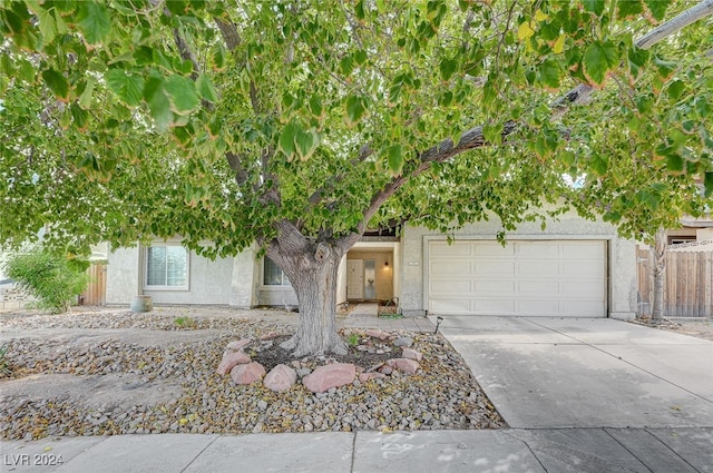 view of property hidden behind natural elements with a garage