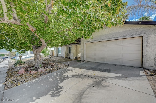 view of property hidden behind natural elements with a garage