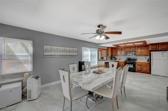 dining space featuring ceiling fan, a wealth of natural light, and a textured ceiling