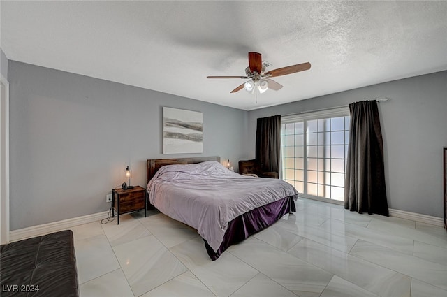 bedroom with ceiling fan and a textured ceiling