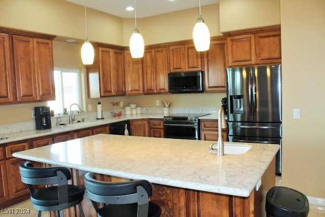 kitchen featuring pendant lighting, sink, stainless steel appliances, a kitchen breakfast bar, and a center island