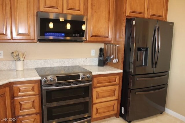 kitchen with stainless steel appliances and light stone countertops