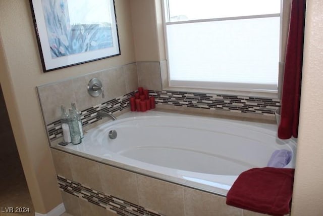 bathroom with a relaxing tiled tub