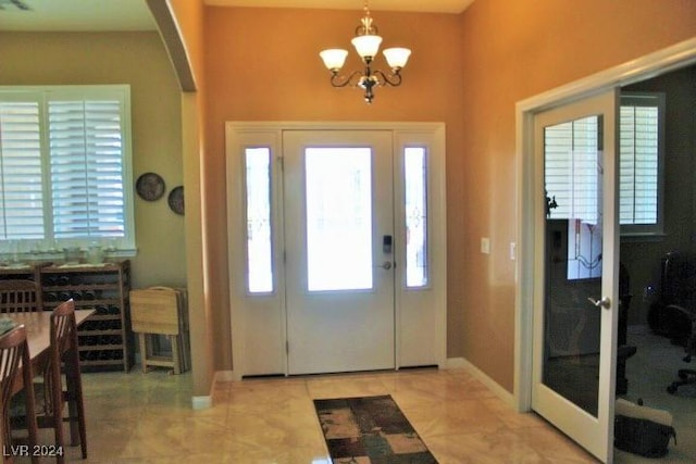 foyer entrance with plenty of natural light and a notable chandelier