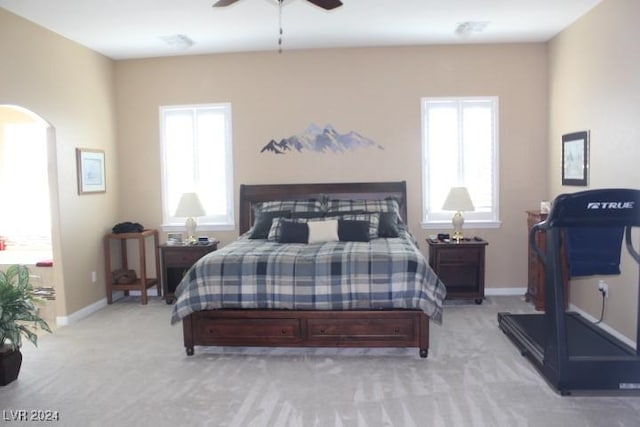 bedroom featuring multiple windows, light carpet, and ceiling fan