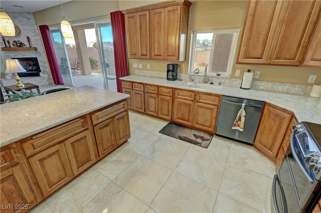 kitchen with pendant lighting, sink, range with electric stovetop, a stone fireplace, and stainless steel dishwasher