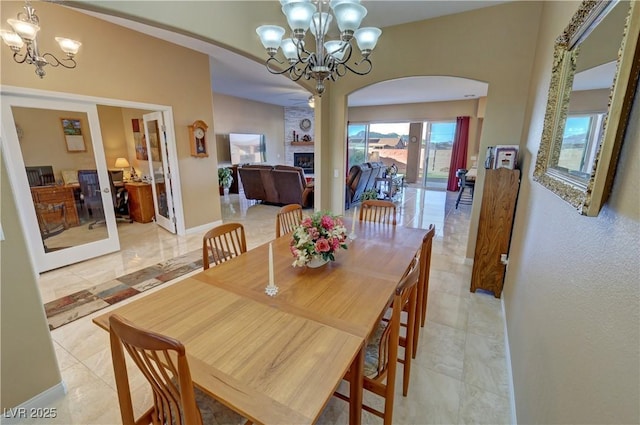 dining area with a large fireplace and a chandelier