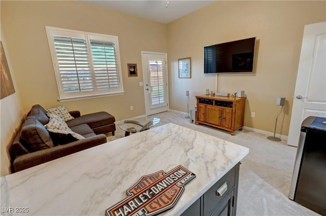 bedroom featuring stainless steel fridge, light carpet, and access to outside