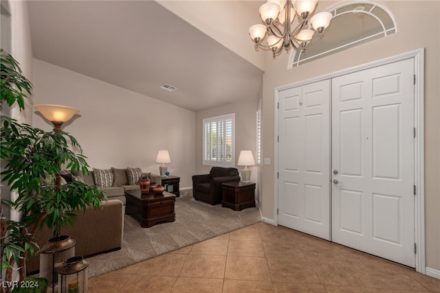 tiled entryway with a chandelier and vaulted ceiling