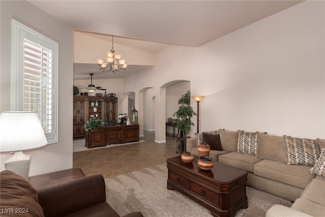 living room featuring ceiling fan with notable chandelier and lofted ceiling