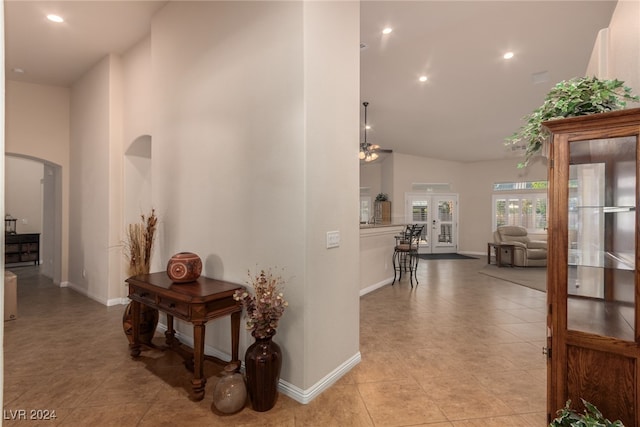 hall featuring french doors, light tile patterned floors, and high vaulted ceiling