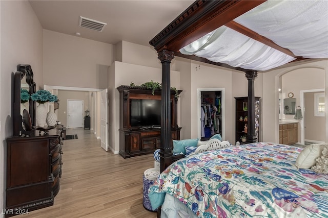 bedroom with a walk in closet, light hardwood / wood-style floors, a closet, and ensuite bathroom