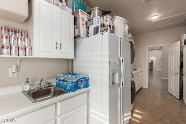 kitchen with sink, white refrigerator with ice dispenser, white cabinets, tile patterned flooring, and washer / clothes dryer