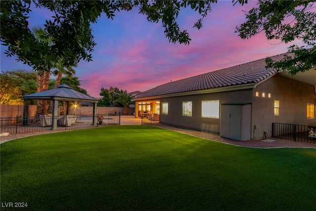 yard at dusk with a gazebo