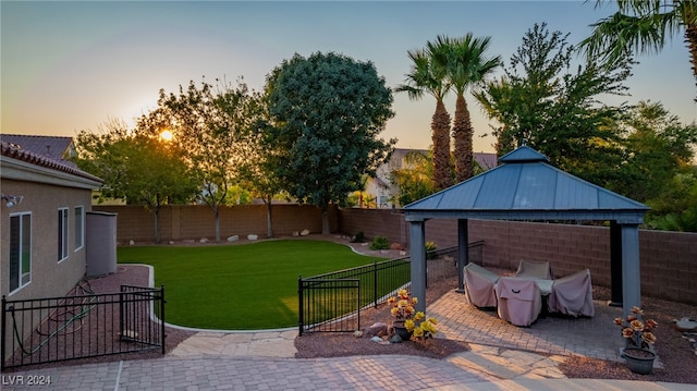 patio terrace at dusk with a lawn and a gazebo