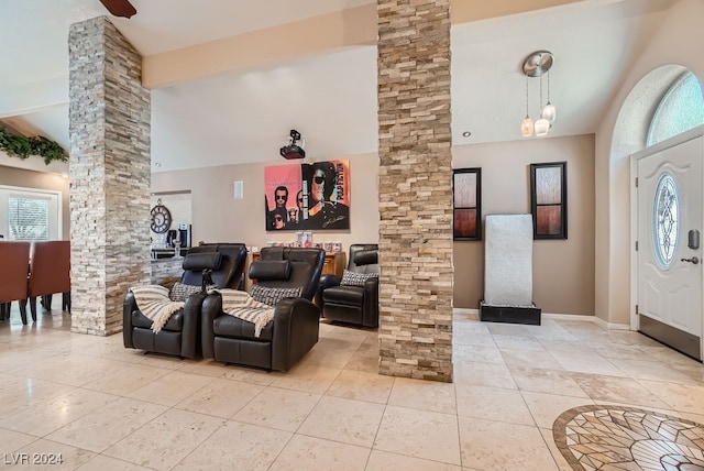 foyer entrance featuring high vaulted ceiling, decorative columns, beam ceiling, and light tile patterned flooring