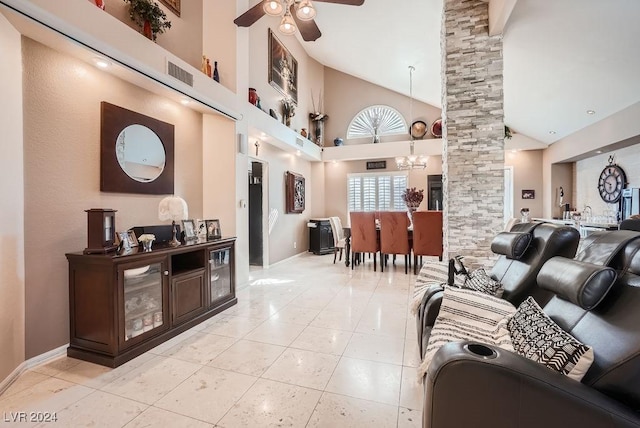 living area with visible vents, high vaulted ceiling, ceiling fan with notable chandelier, light tile patterned floors, and decorative columns