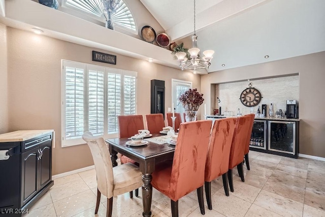dining area with an inviting chandelier, light tile patterned flooring, baseboards, and lofted ceiling