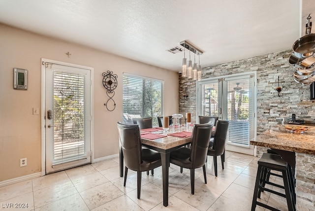 tiled dining area featuring a textured ceiling