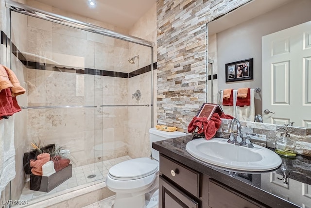 bathroom featuring a shower with door, vanity, toilet, and tile patterned flooring