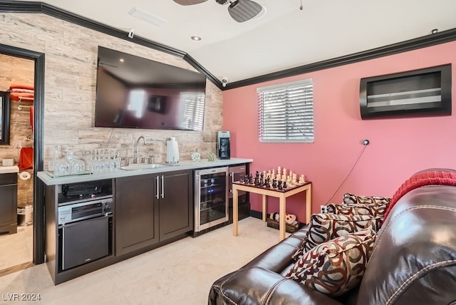 bar with ornamental molding, beverage cooler, sink, and lofted ceiling