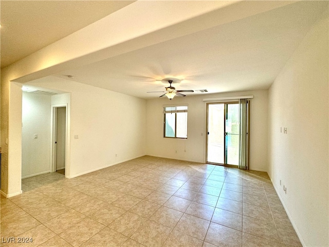 tiled empty room featuring ceiling fan