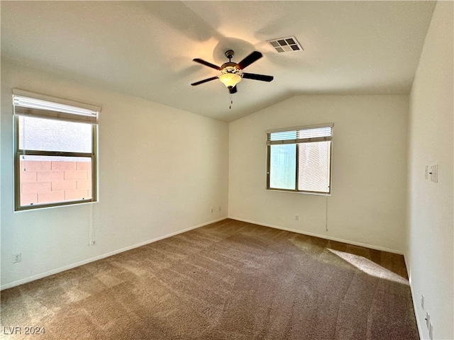 empty room featuring lofted ceiling, a wealth of natural light, ceiling fan, and carpet floors