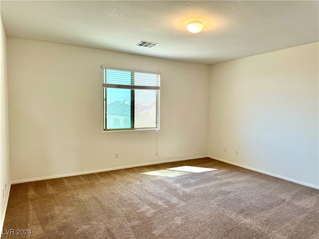 empty room featuring a textured ceiling and carpet floors