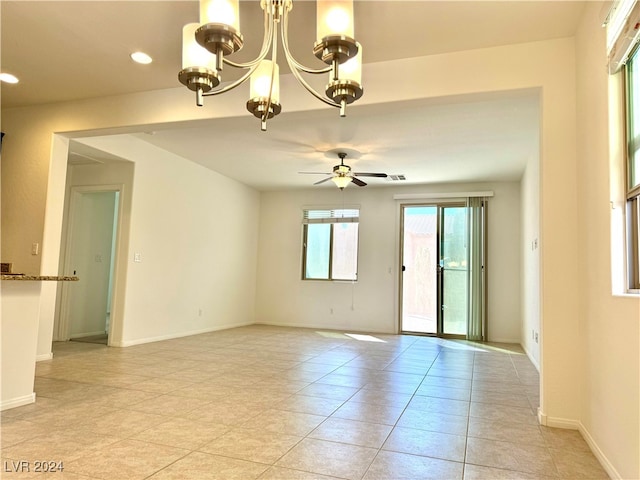 unfurnished room with ceiling fan with notable chandelier and light tile patterned flooring