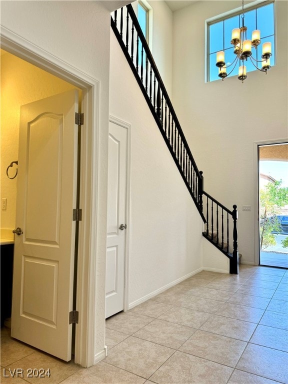 staircase featuring tile patterned flooring and an inviting chandelier